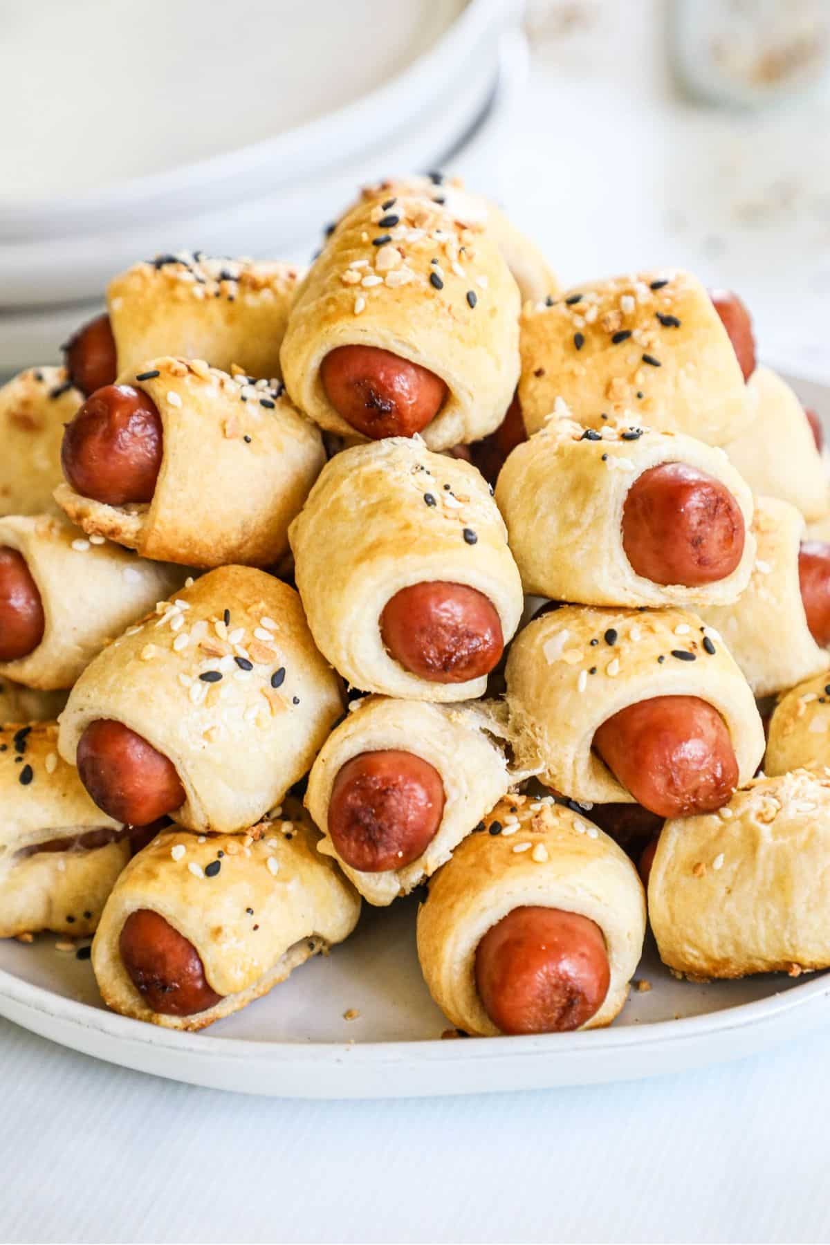 pile of mini pigs in a blanket on a white plate