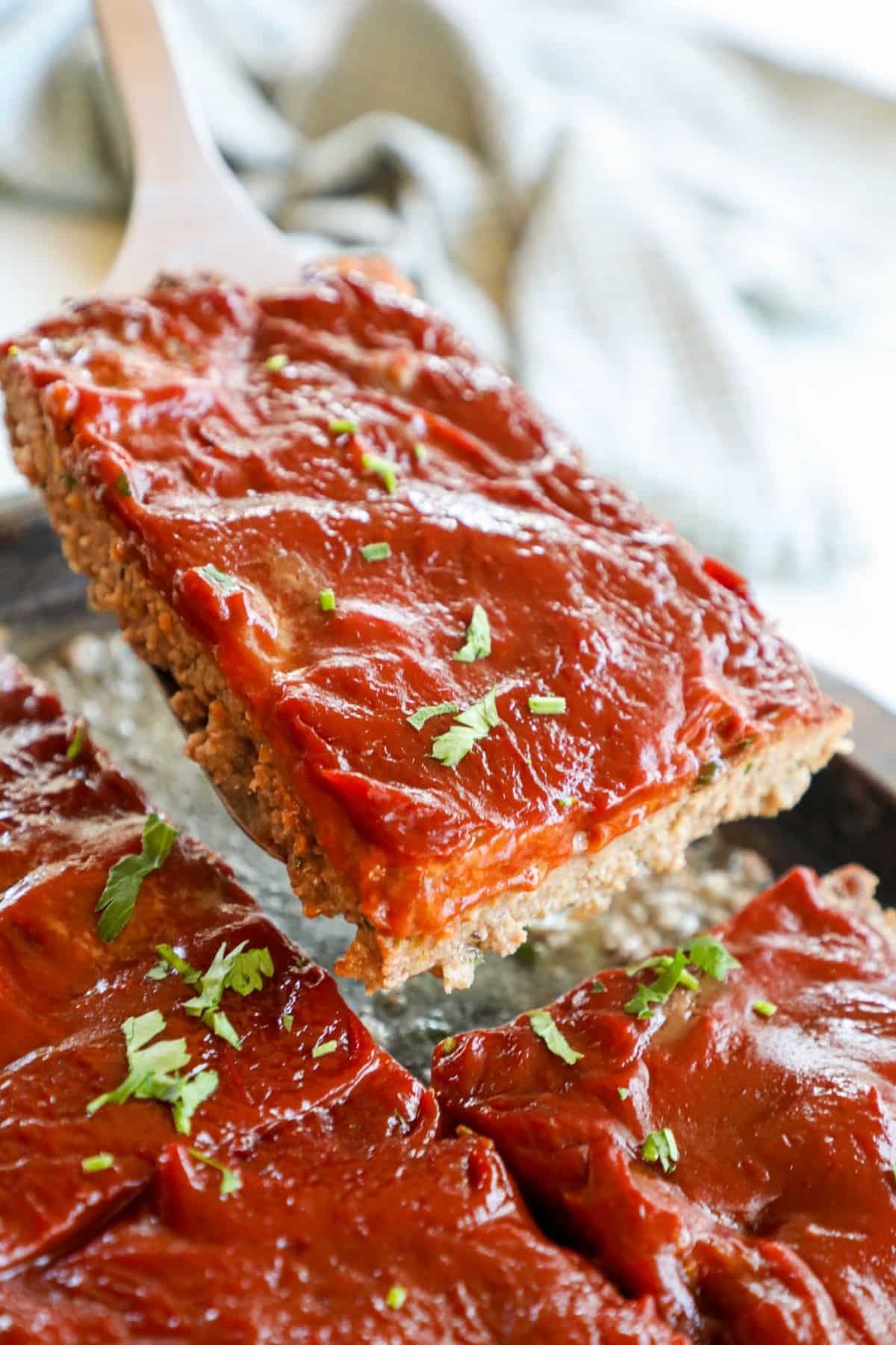 a serving of meatloaf lifted from a sheet pan
