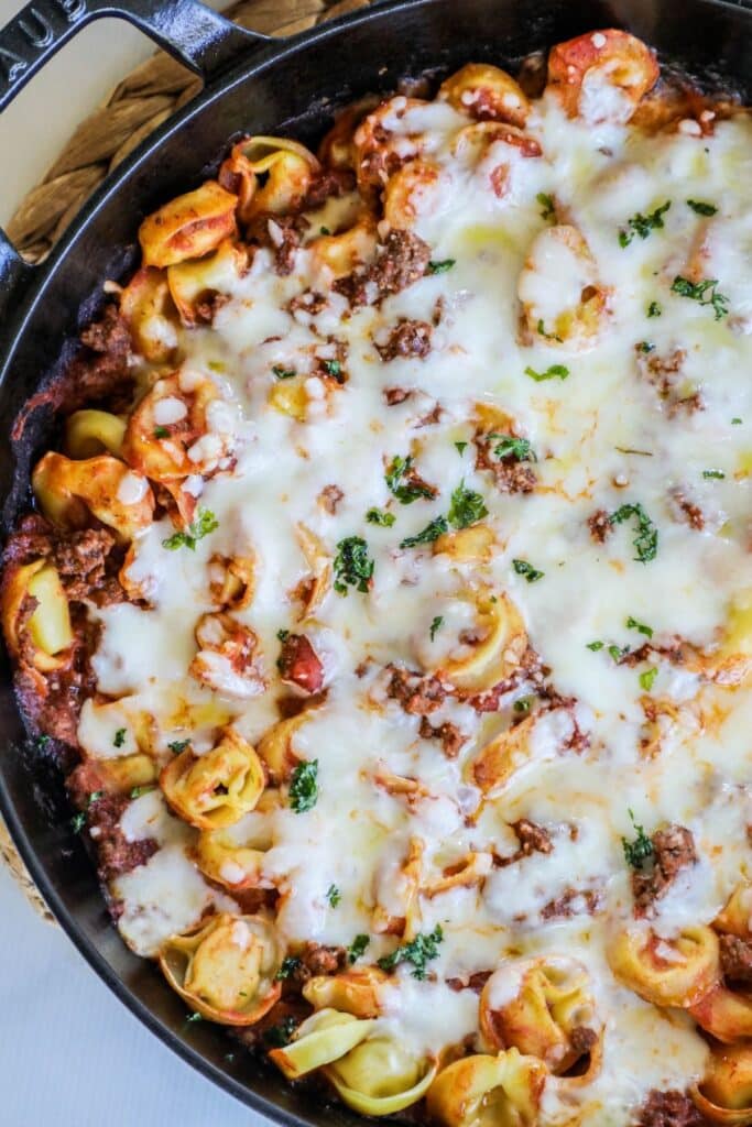 tortellini casserole covered with melted mozzerella cheese in a skillet