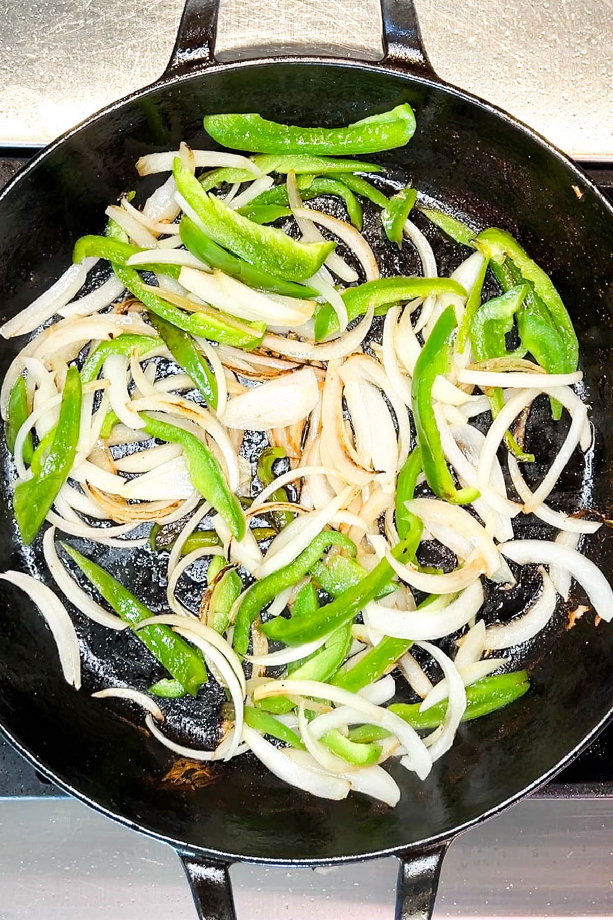 Step 3 for making chicken cheesesteak sandwiches: Saute the peppers and onions. 