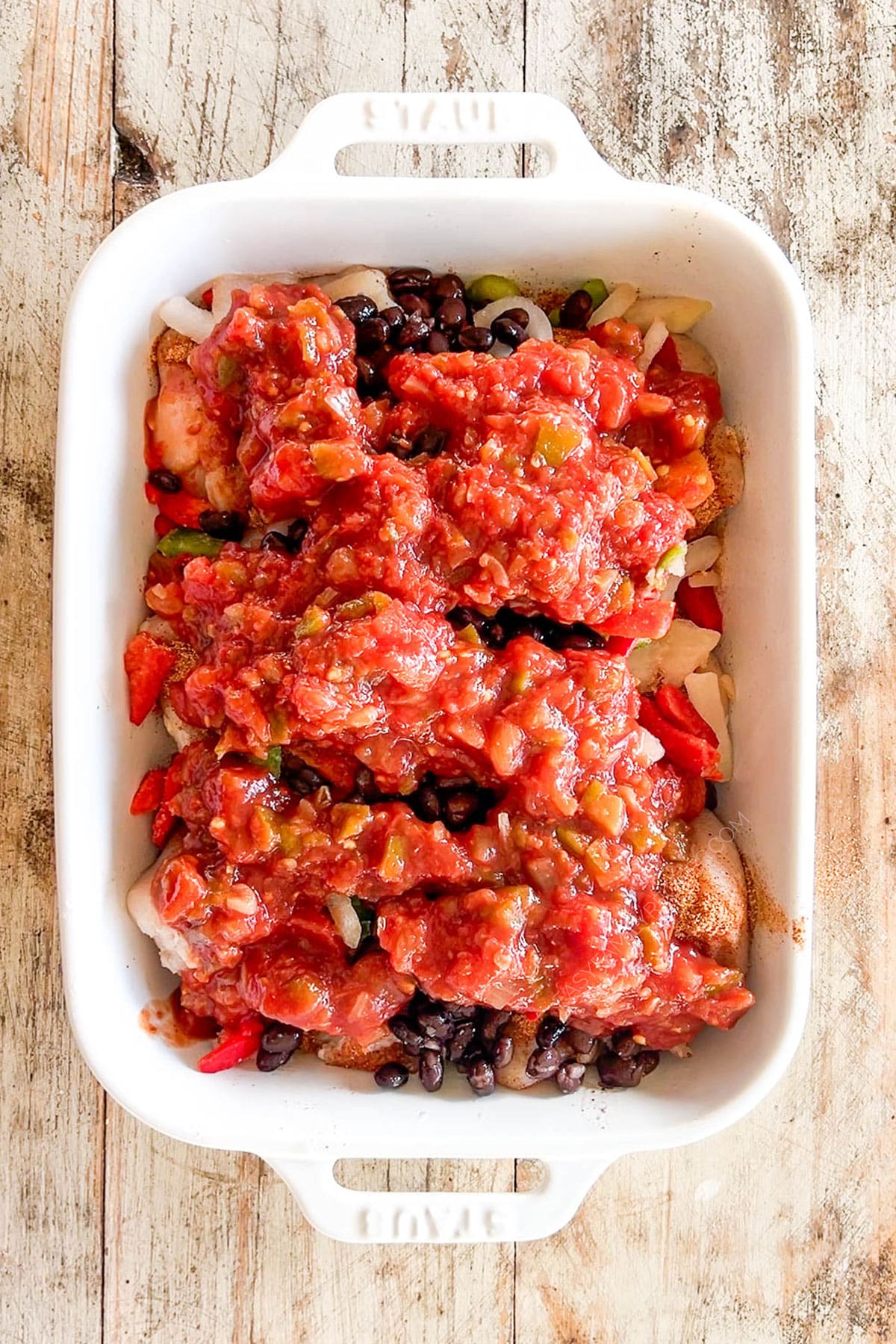 Salsa and beans are added to the top of Mexican Chicken Bake