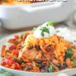 A serving of Mexican Chicken Bake on a white plate with sour cream and cilantro. The text reads, "Mexican Chicken Bake."