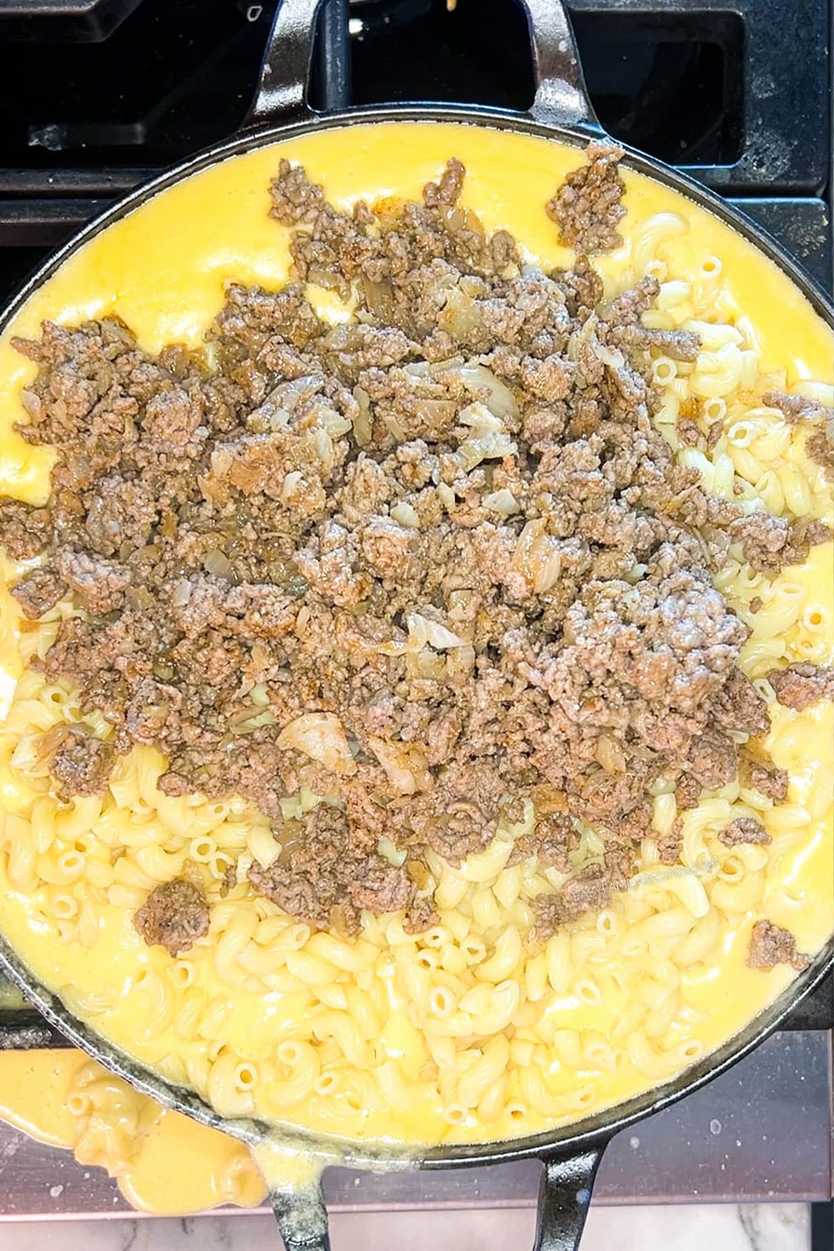 Step 5 for how to make Loaded Mac & Cheese with Ground Beef - stir in the cooked ground beef