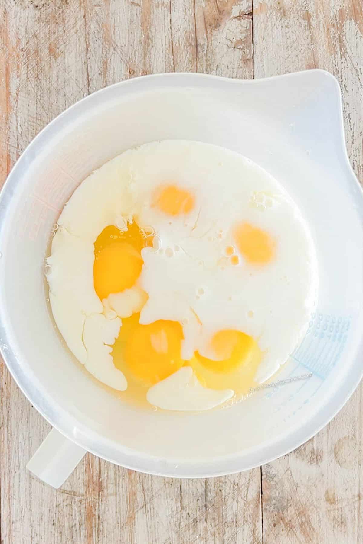 Step 1 of how to make Marry Me Chicken Quiche - mix the eggs, milk, and cream together in a bowl.