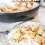 Bang bang chicken over rice on a white plate with a skillet full of chicken in the background. The text reads, “Bang Bang Chicken Bites”