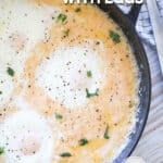 Cheesy grits and eggs in a castiron pan. The text reads, "Cheesy Grits with Eggs"