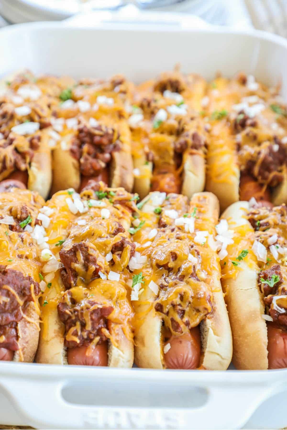 baked chili cheese dogs in a white baking dish