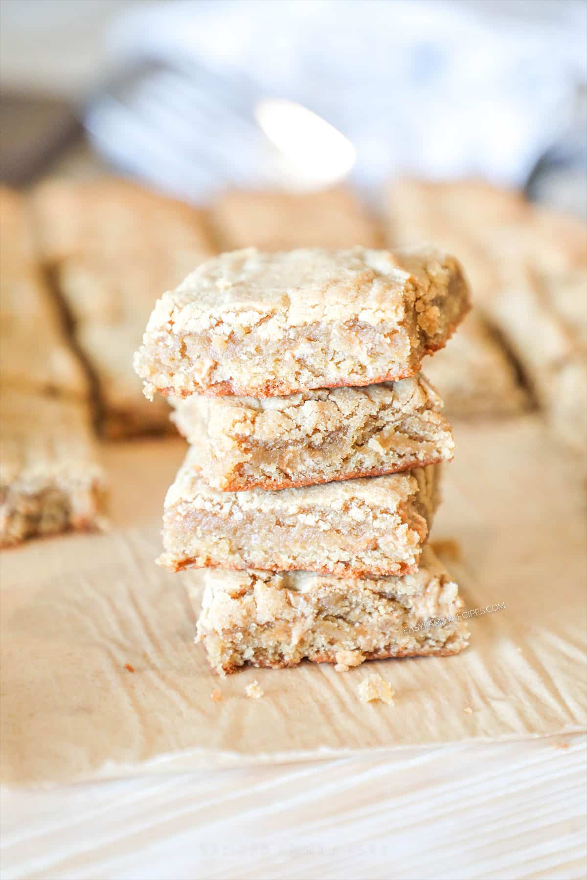 four blondies stacked on a cutting board. 