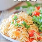 A serving of Boursin baked orzo on a white plate with a side salad. The text reads, “Creamy Boursin Baked Orzo”
