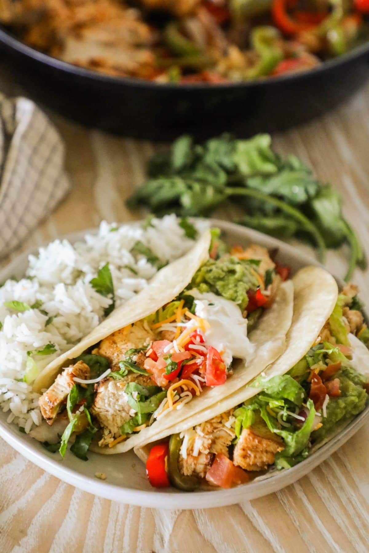 a plate with 2 fajjita tacos and a slide of cilantro lime rice