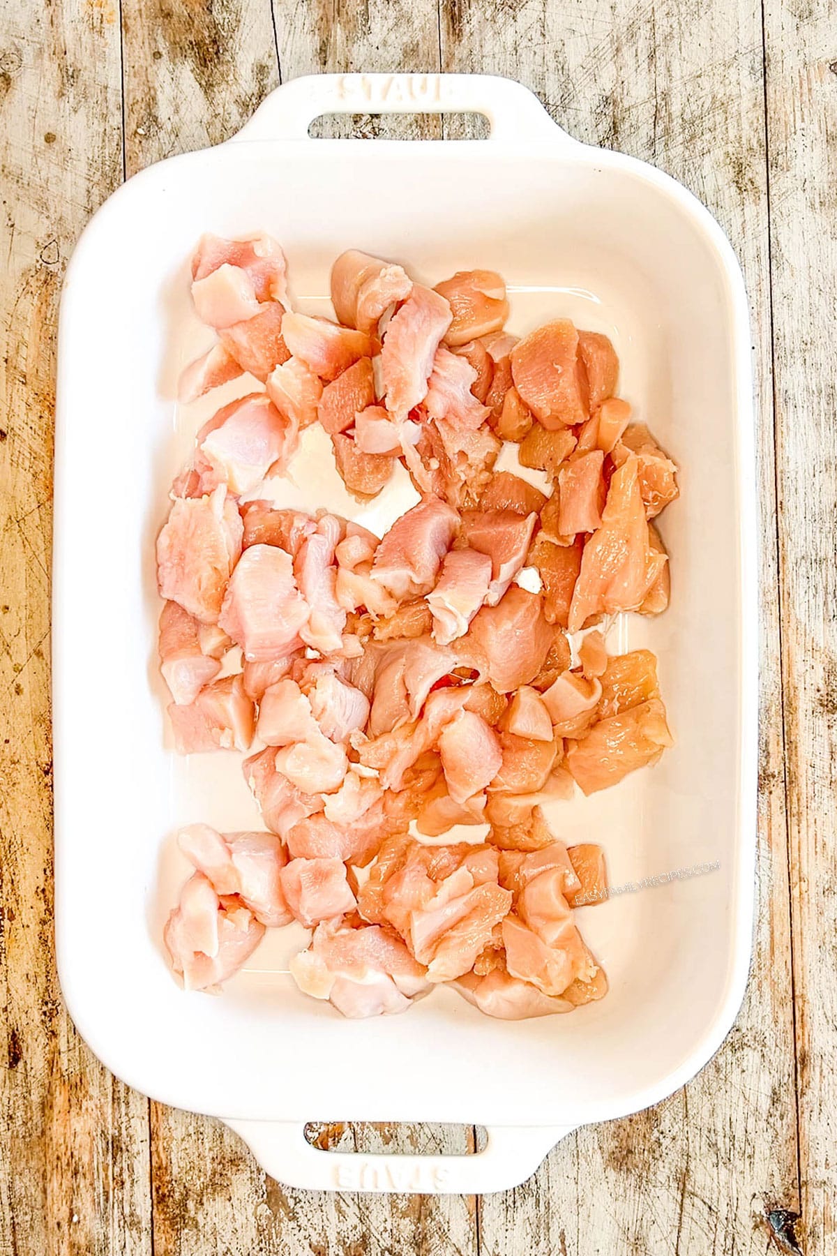 Step 1 for how to make Chicken Schwarma Bites - place chicken in an oven-safe baking dish.