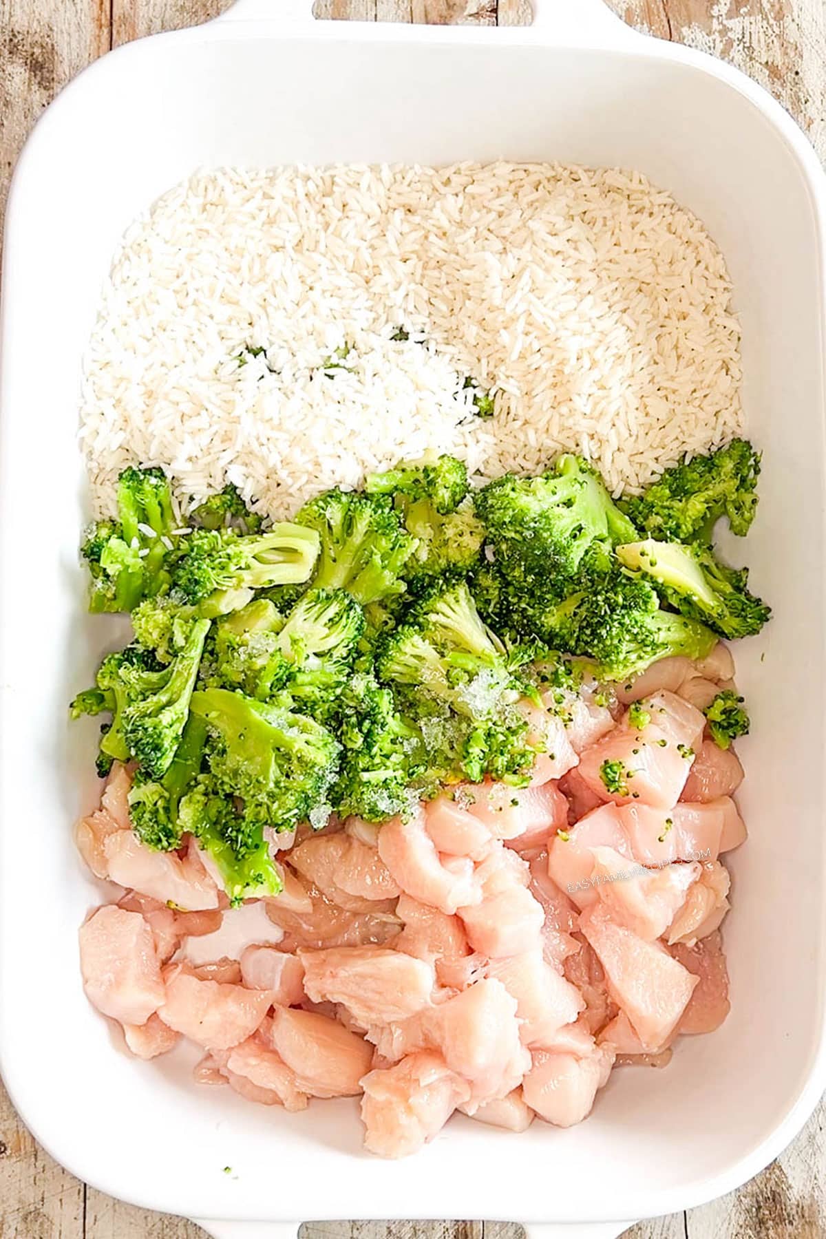 Step 1 for making teriyaki chicken casserole - chicken, rice, and broccoli go in the casserole dish