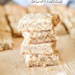 four blondies stacked on a cutting board.