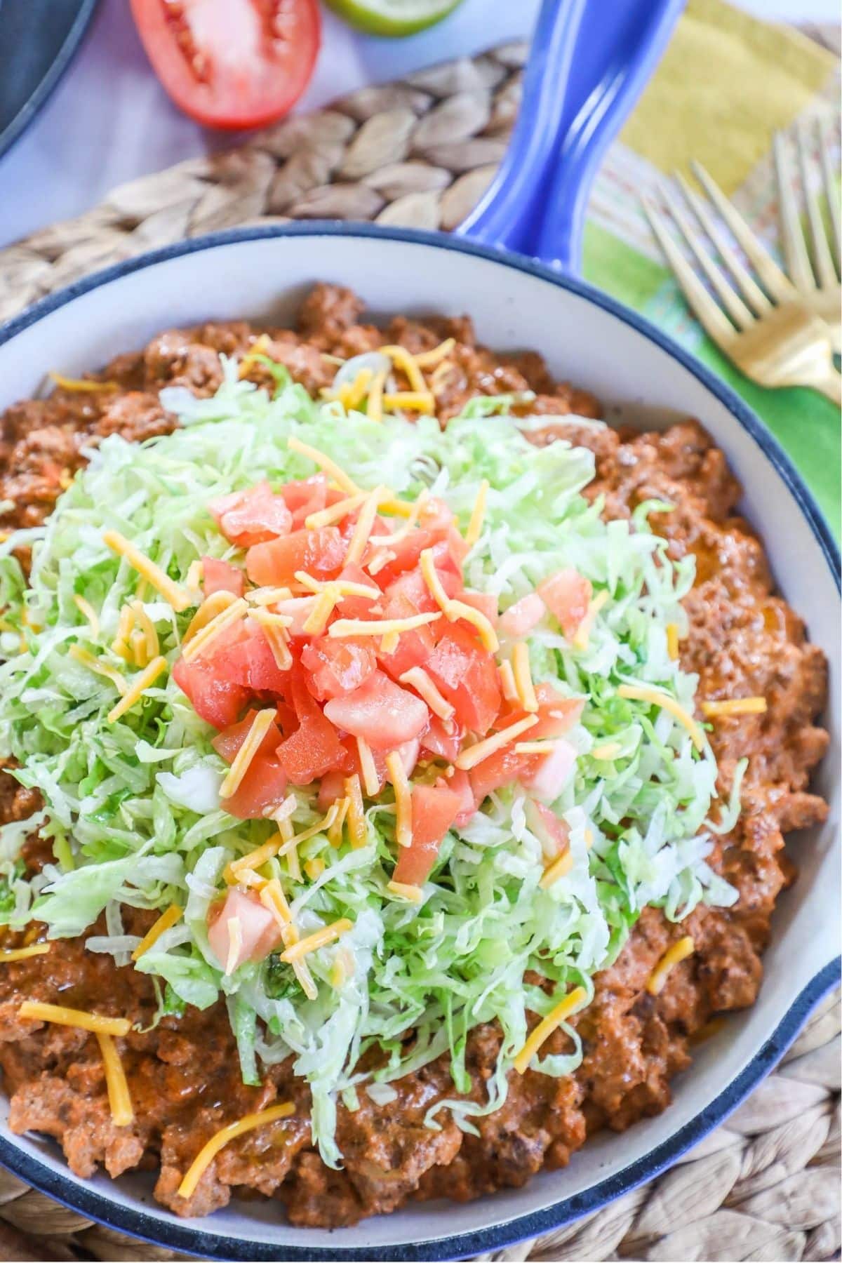 cheesy taco skillet topped wiht lettuce tomato and cheese