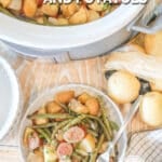 A bowl full of sausage and potatoes along with a Crock Pot full of the sausage and potatoes on a wooden surface. The text reads, “Crockpot Sausage and Potatoes”