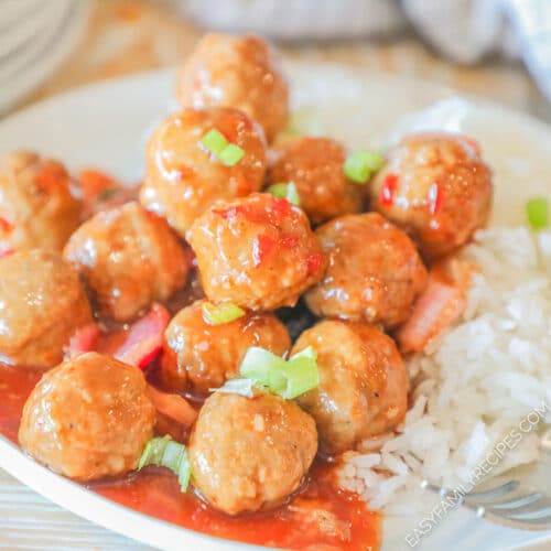 A serving of Crockpot Sweet Chili Meatballs on a white plate with rice on the side