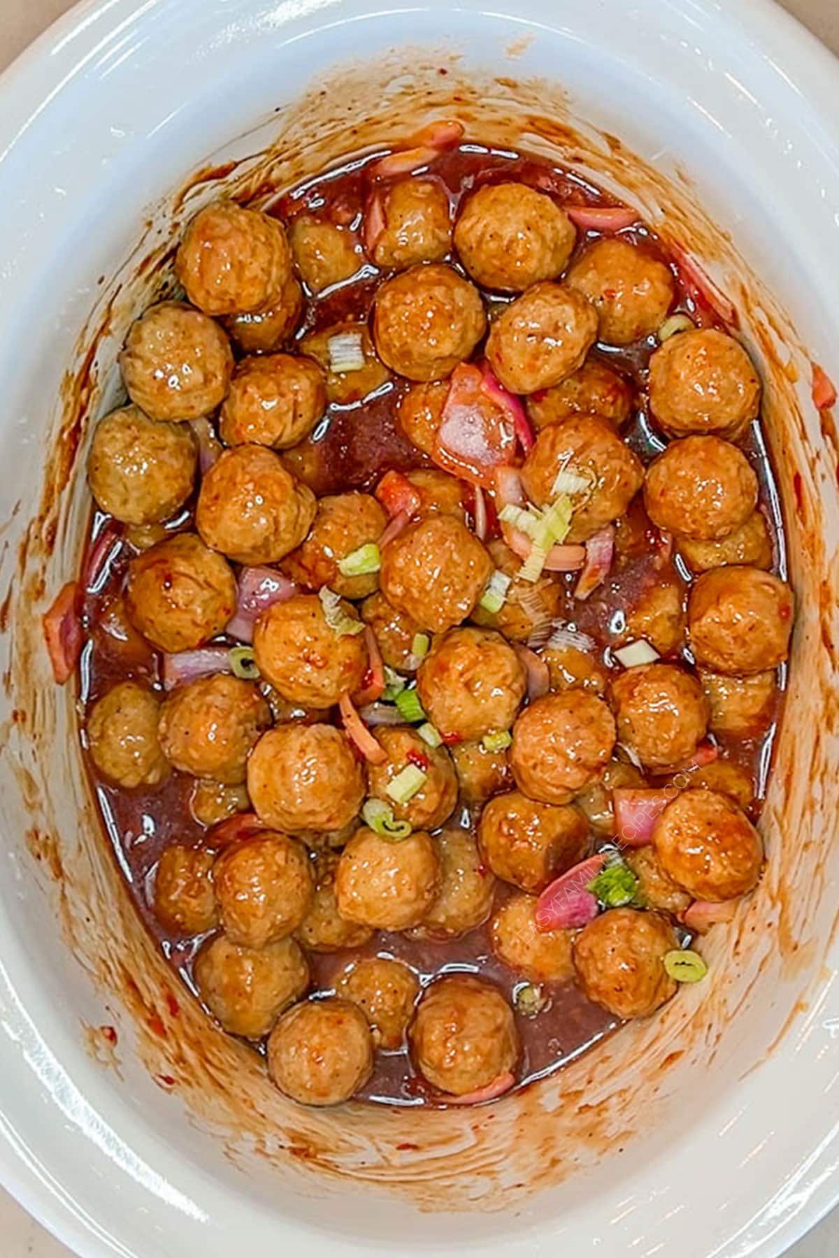 Step 4 of making Crockpot Sweet Chili Meatballs - cook in Crockpot until warmed through.