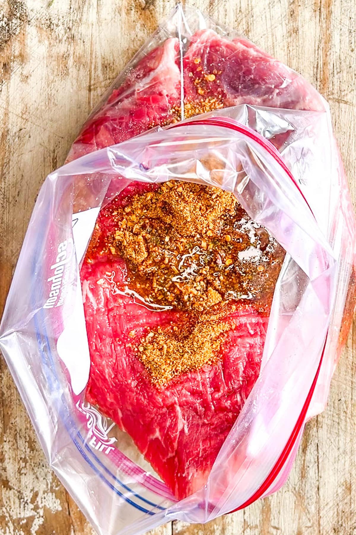 Step 1 of how to make sheet pan steak fajitas: Place the beef and marinade ingredients into a plastic bag.