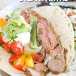 A white plate with a sheet pan steak fajita. The text reads, “Sheet Pan Steak Fajitas”
