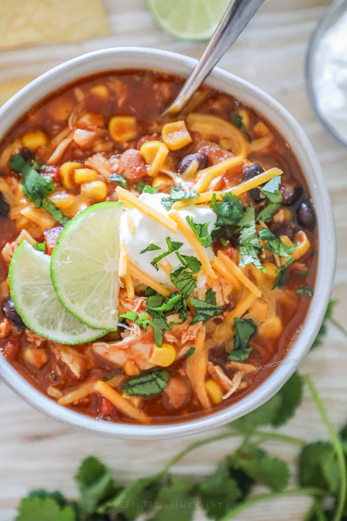 A top view of a bowl full of Crockpot Chicken Taco Soup with lime and sour cream