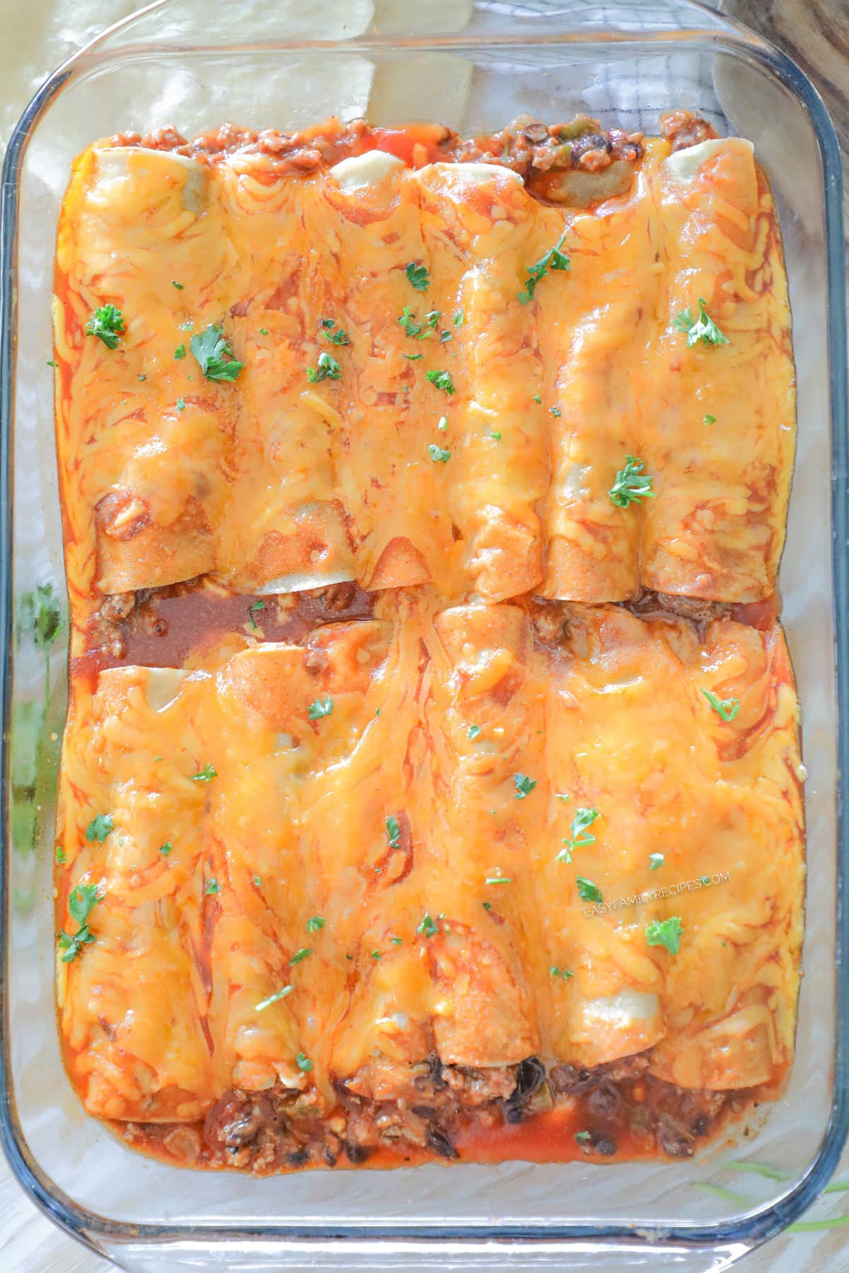 finished chili cheese enchiladas in a baking dish.