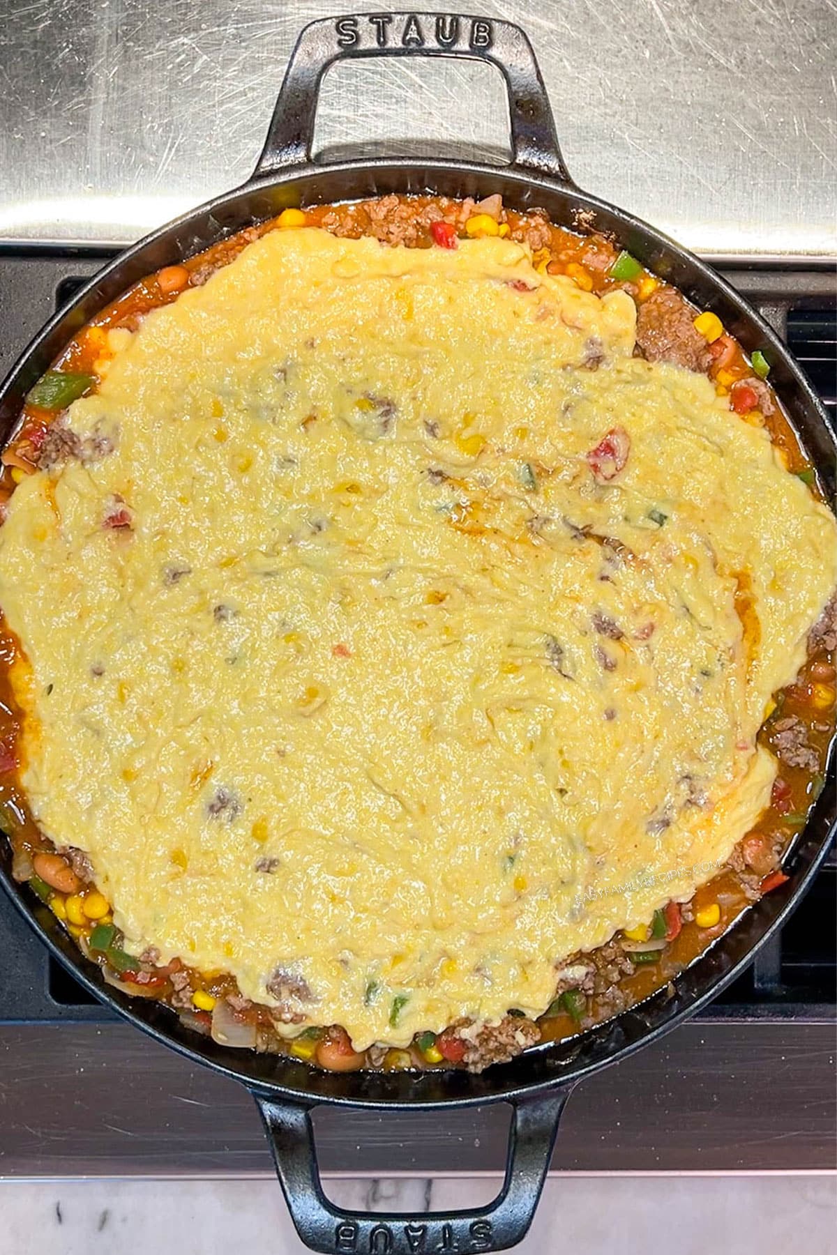 Step 5 of how to make Cowboy Casserole - spread cornbread batter over the top
