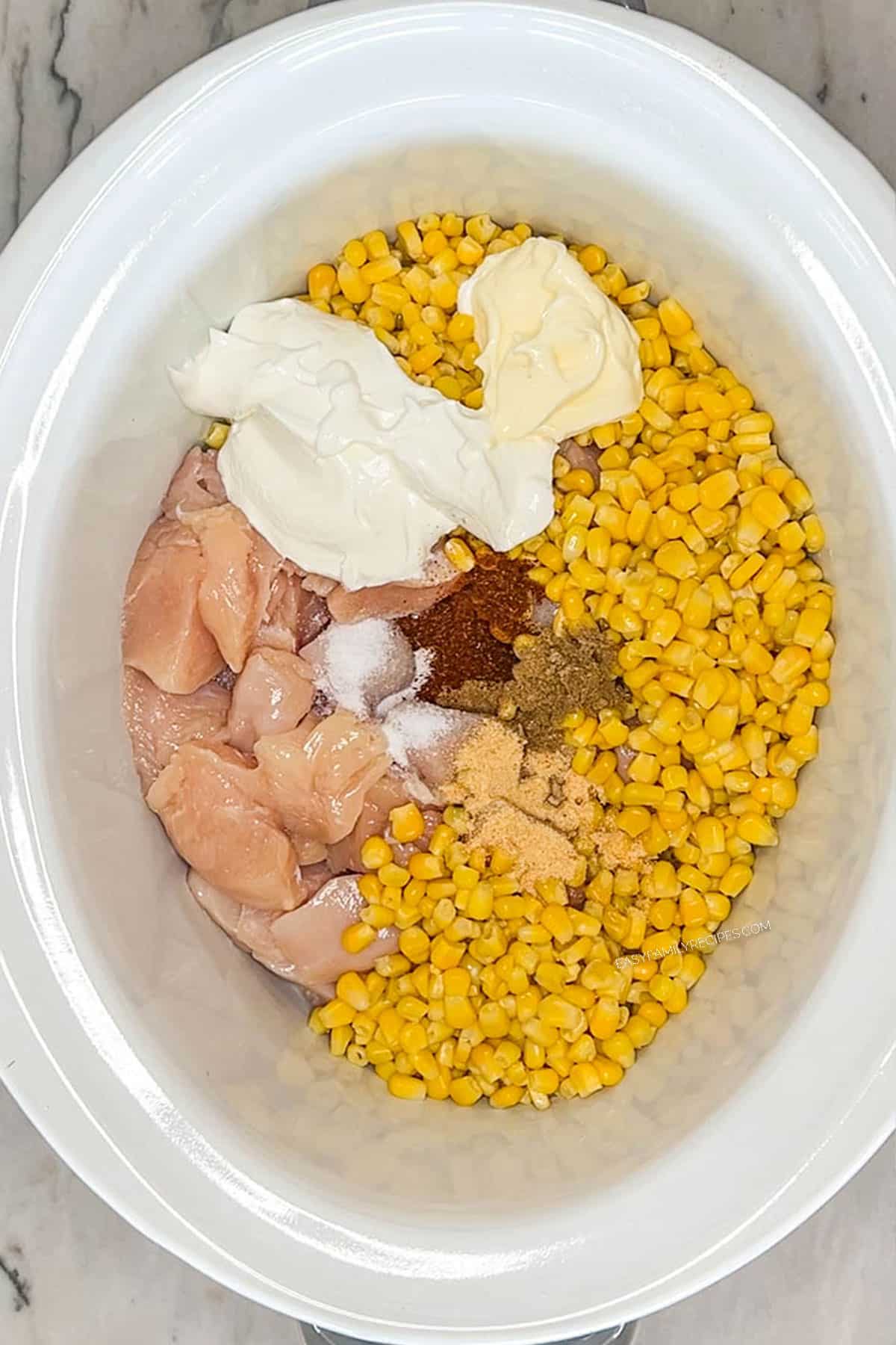 Step 1 for how to make Crockpot Mexican Street Corn Chicken: Add the ingredients to the Crockpot.