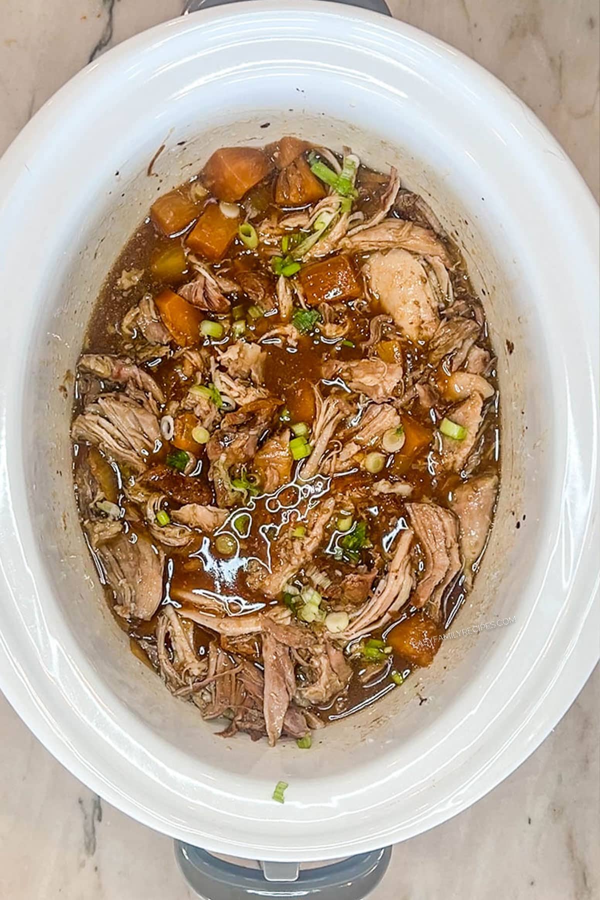 Shredded pork added back to the crockpot with the rest of the ingredients.