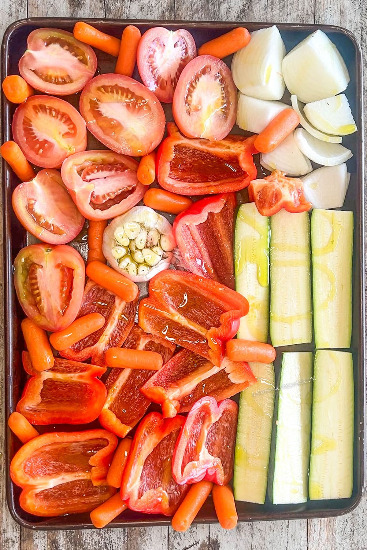 Step 1 for how to make Roasted Veggie Soup: Add the veggies to a sheet pan and bake.