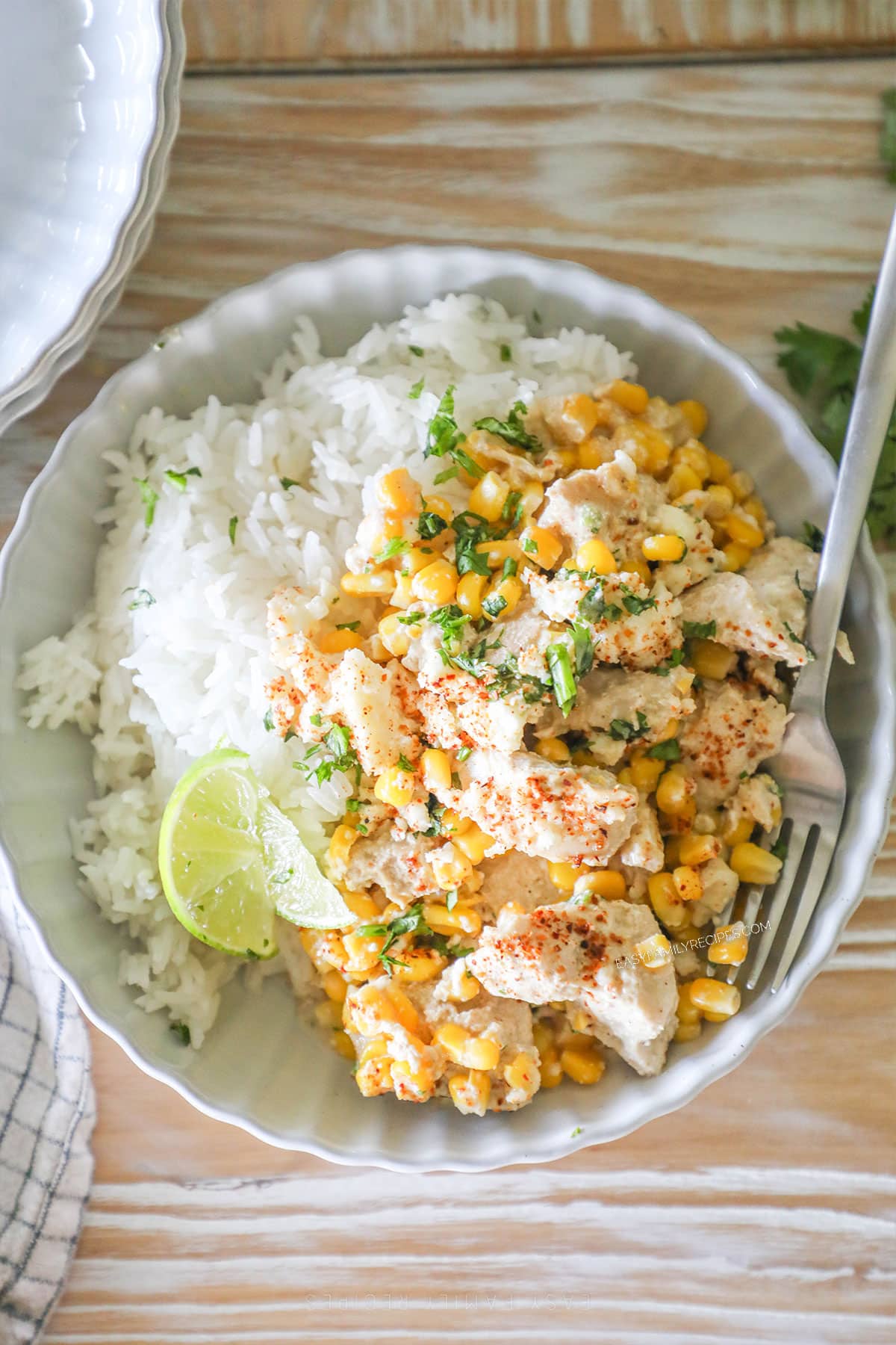 Crockpot Mexican Street Corn Chicken top view of a bowl with rice and fresh lime wedges.