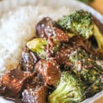 A white bowl full of Crockpot Beef and Broccoli with rice.