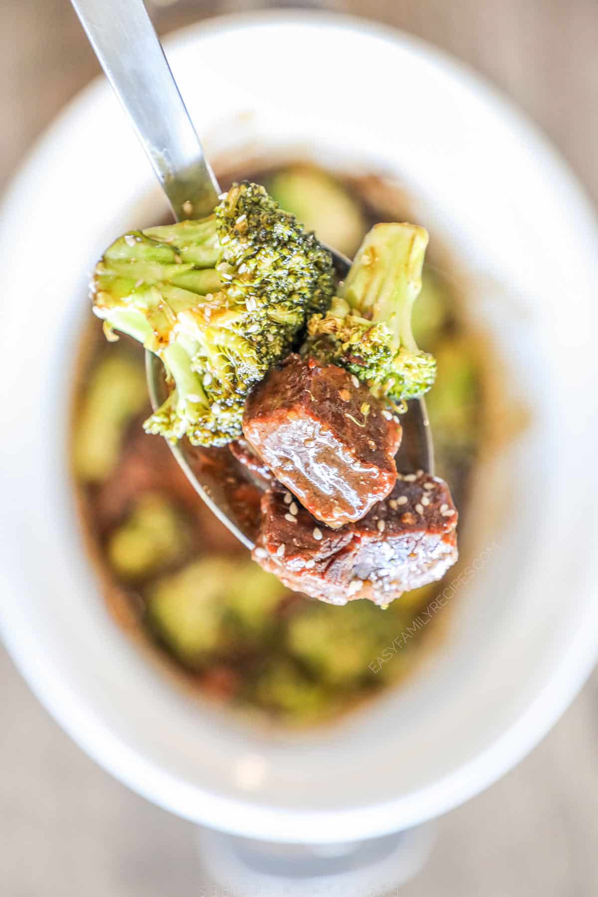 A serving spoon scoops out a serving of Crockpot Beef and Broccoli 