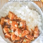 Top view of a white bowl full of Crockpot Orange Chicken with rice. The text reads, “Crockpot Orange Chicken”