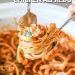 A fork twirls the fettucine for Crockpot Sun Dried Tomato Chicken Alfredo. The text reads, “Crockpot Sun Dried Tomato Chicken Alfredo”