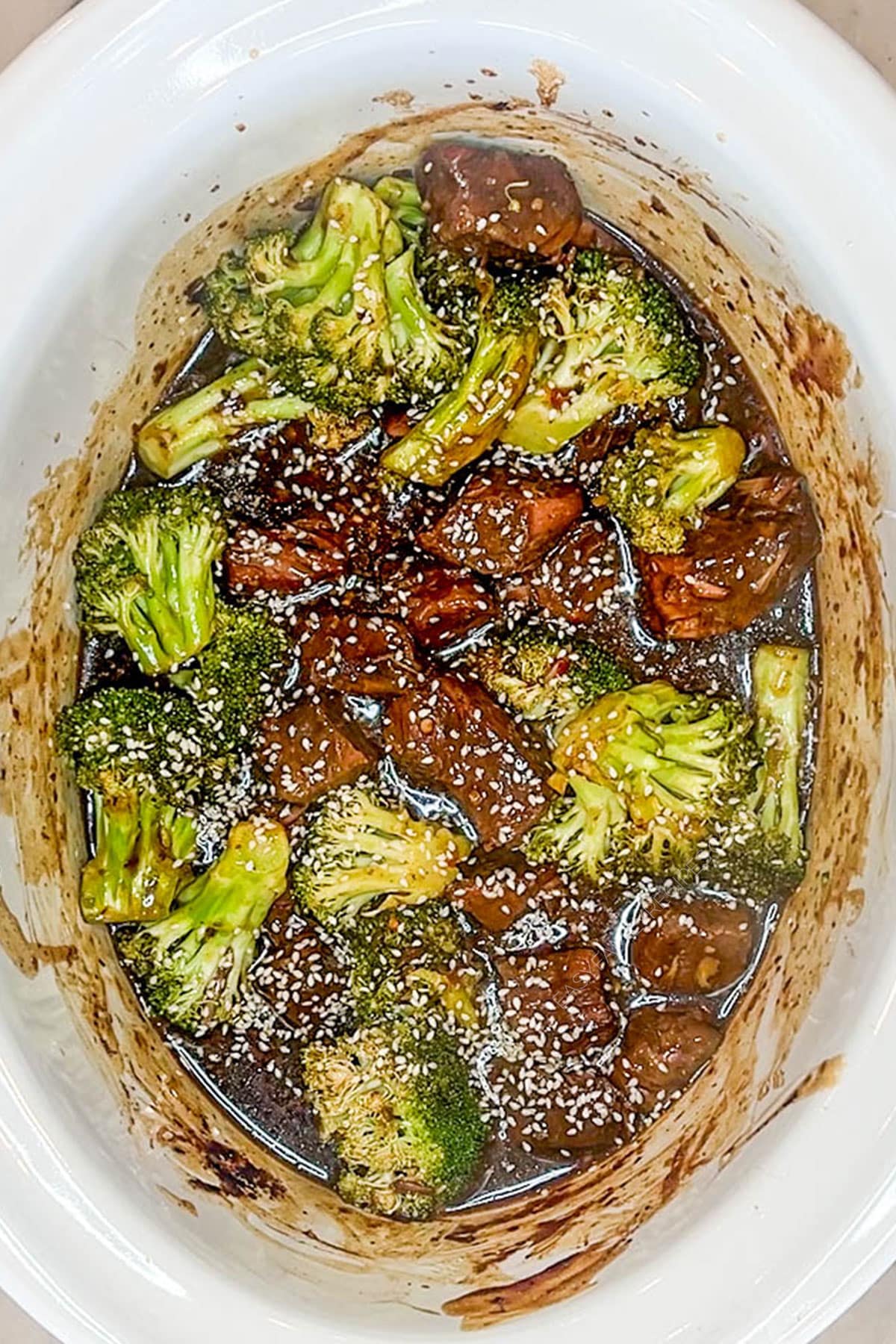 Step 4 for how to make Crockpot Beef and Broccoli. Top view of a white Crockpot full of Crockpot Beef and Broccoli