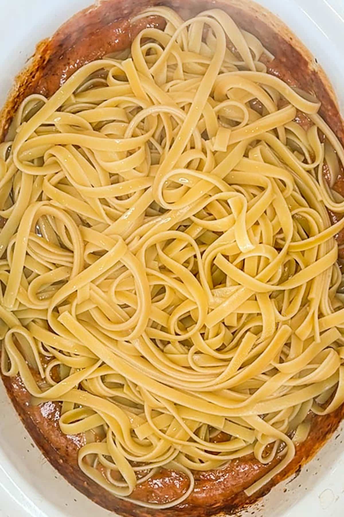 Step 4 for how to make Crockpot Sun Dried Tomato Chicken Alfredo: Add the cooked pasta and Parmesan