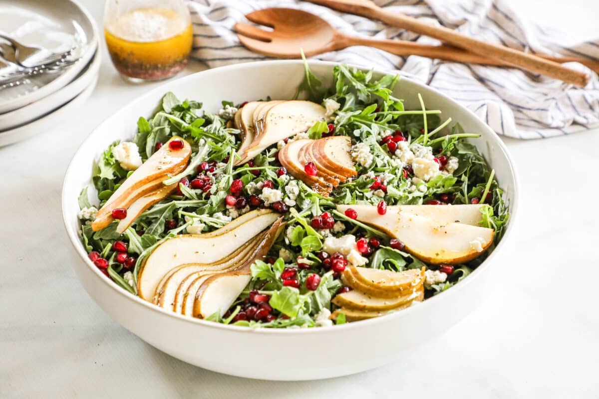arugula pear salad in a white bowl
