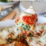 Creamy spinach chicken lasagna rolls ups in a baking dish with a spatula taking one.