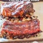 two pieces of honey bbq ribs on a cutting board.
