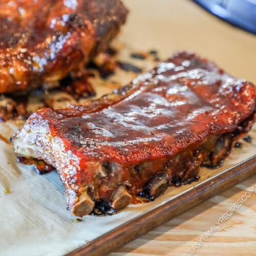 cooked honey bbq ribs on a cutting board.
