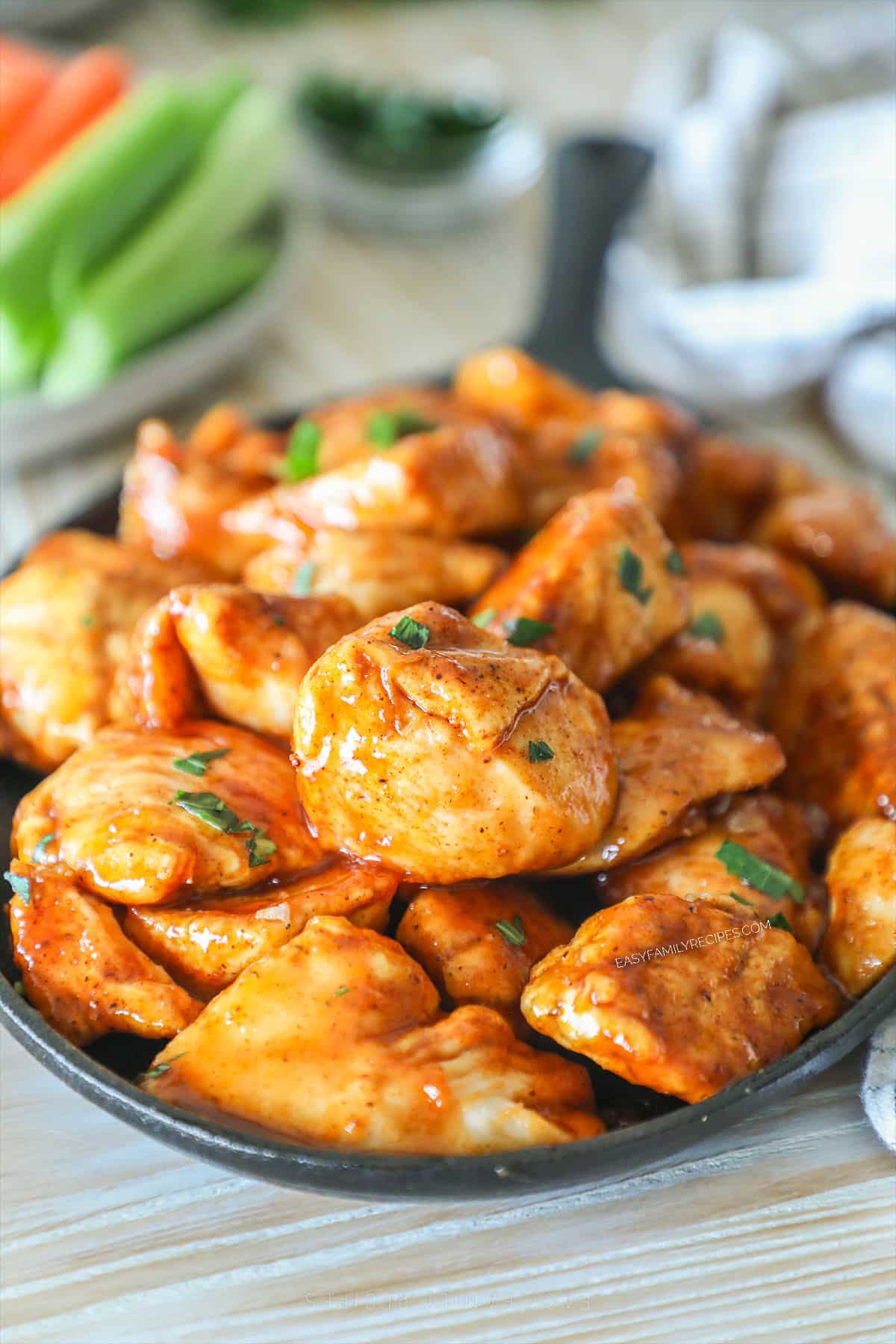 Side view of BBQ honey boneless wings served on a cast iron skillet.