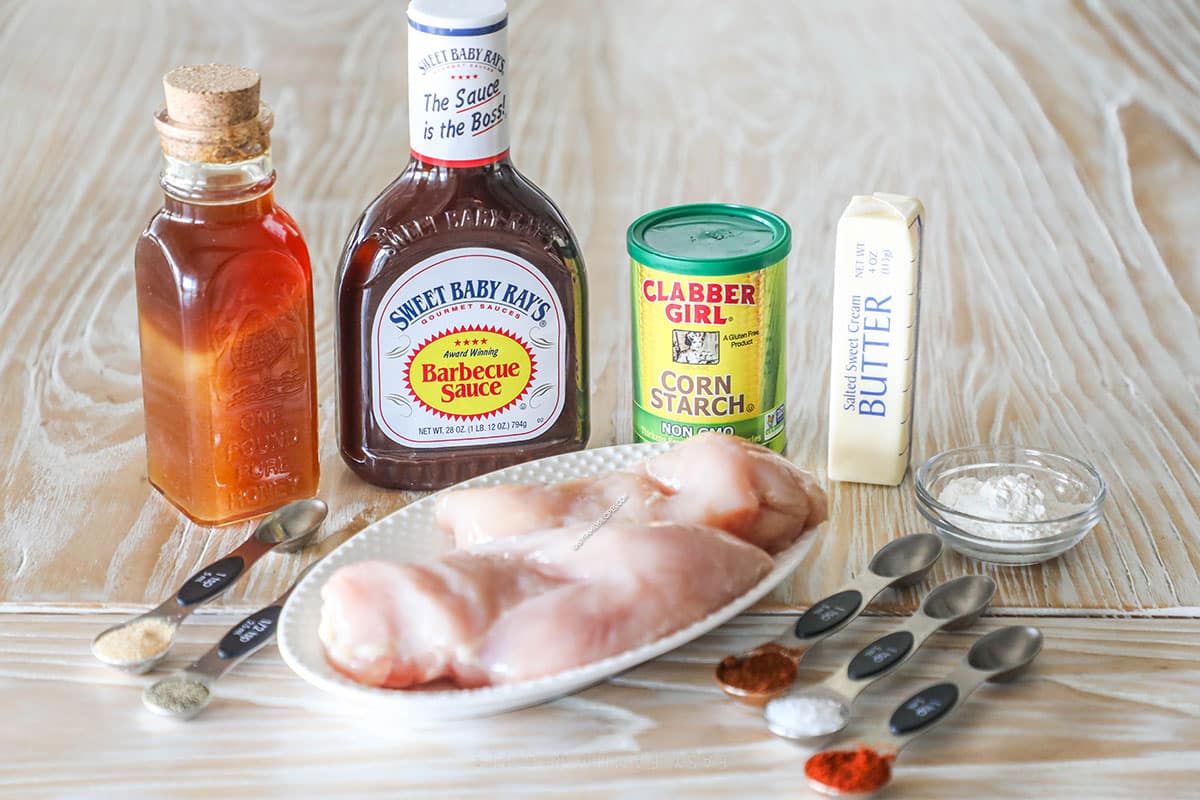 Ingredients needed to make honey BBQ boneless wings on a wooden background.