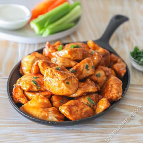 Honey BBQ boneless chicken wings served on a cast iron serving platter.