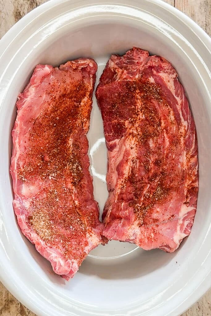 an uncooked rack of ribs in a crockpot.