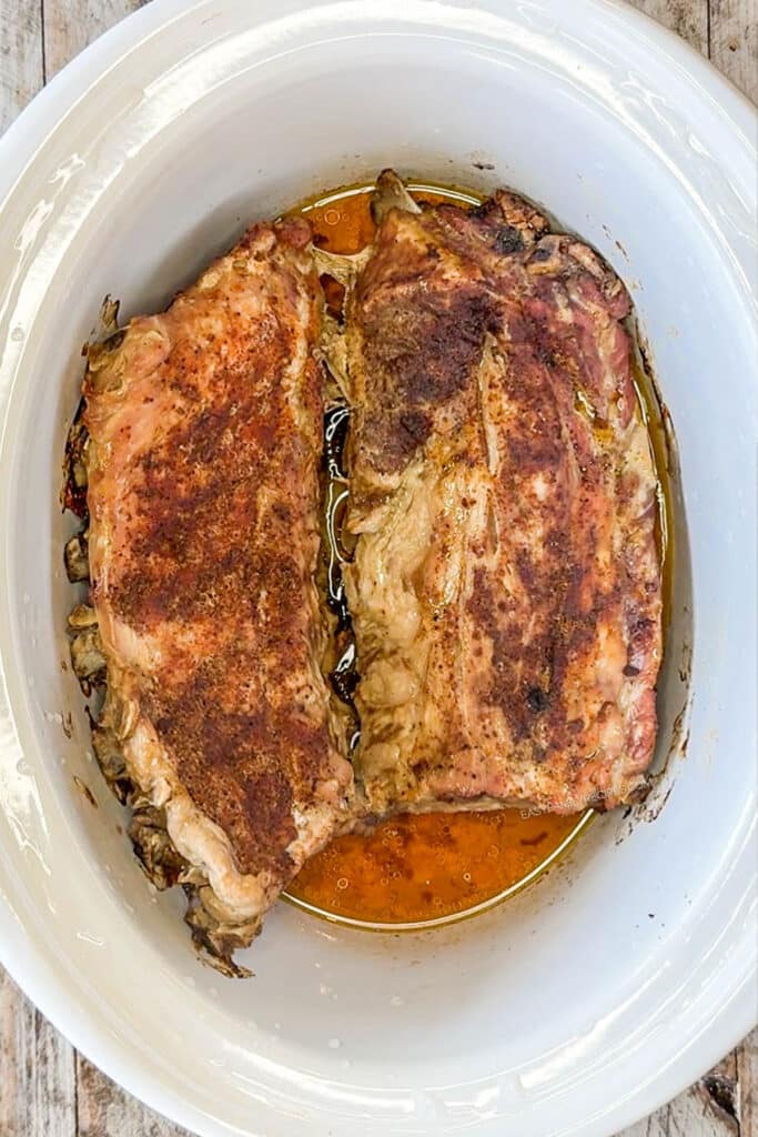 a cooked rack of ribs in a slow cooker.