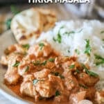 Chicken tikka masala served on a plate with rice on the side.