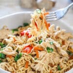 A fork lifts a bite of ramen out of the bowl