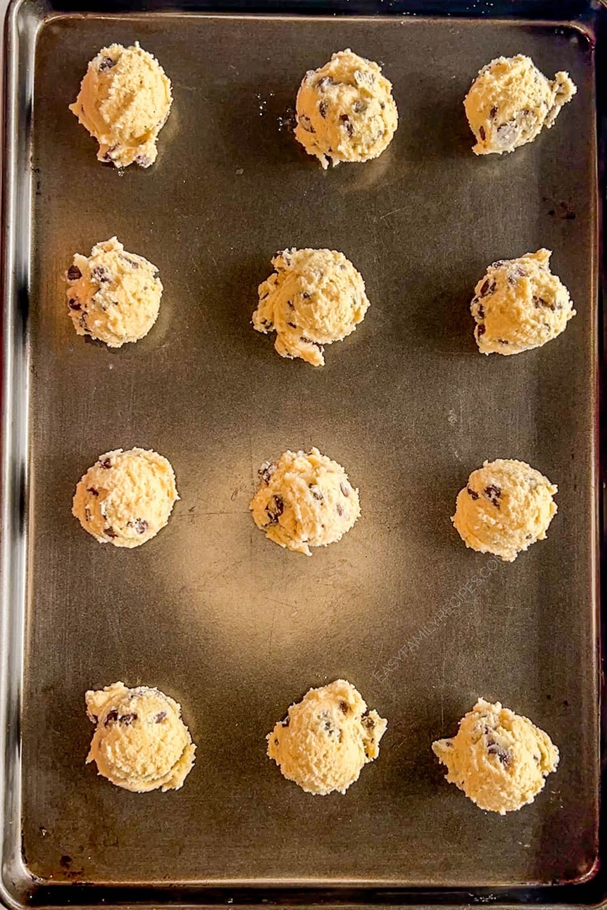cookie dough balls on a baking sheet.