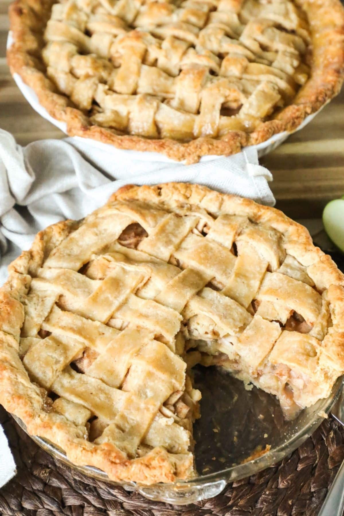 apple pie in a glass dish with one slice taken out