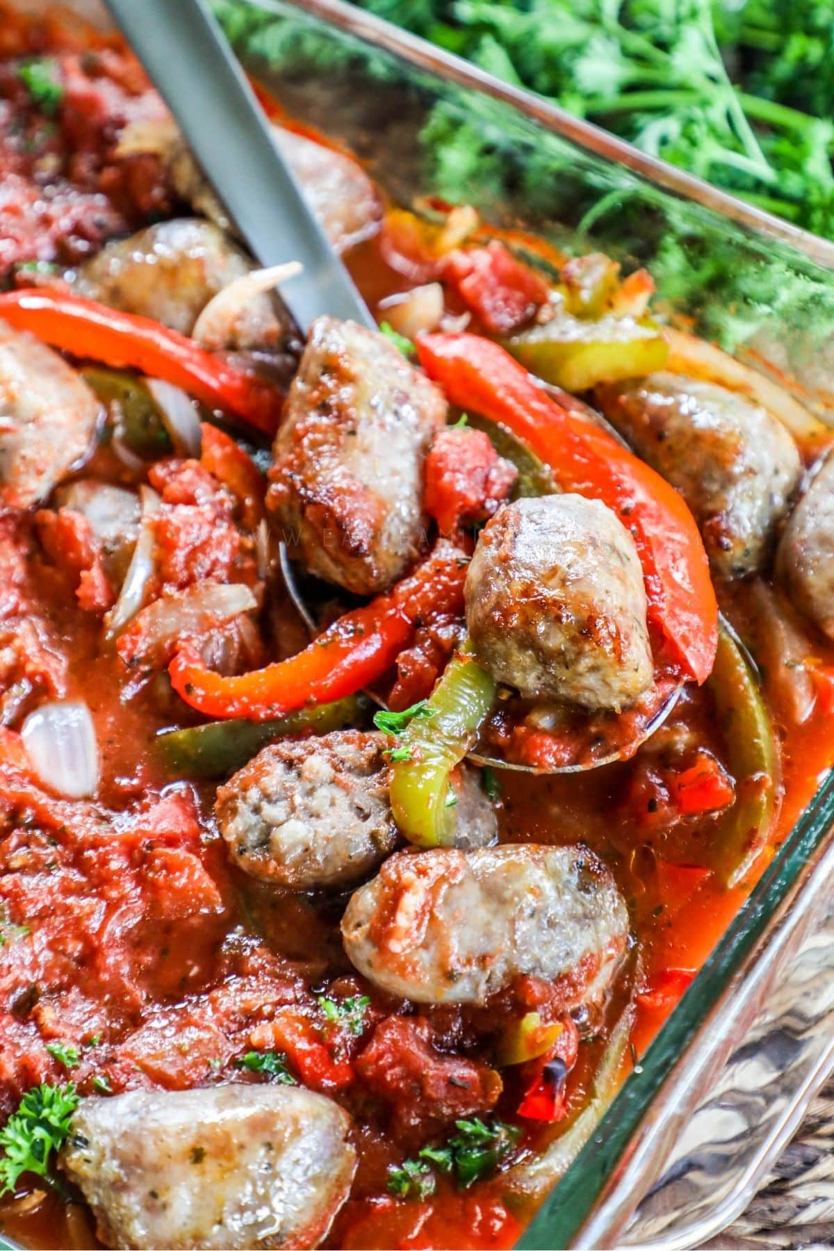 cooked italian sausage and peppers in a glass baking dish